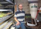 Russell Kleinschmidt, rural Staples, owns and operates Kleinschmidt Farms, a CSA (Community Supported Agriculture) farm. He and his wife, Jessica, sell over 60 varieties of garden produce, all started from seed. Kleinschmidt mixes his own potting soil and plants the seeds in 20-row seed flats kept under lights in his basement. He is pictured on March 20, with seeds that have begun to sprout and will be transplanted in the near future. (Staples World photo by Dawn Timbs)