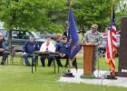 Above left, Larry Doucette, right, gave credit to the veterans no longer with us during his Memorial Day address to the crowd gathered at Evergreen Hill Cemetery in Staples May 29. Seated, from left, are Don Amundson, Arlene Grover and Huck Holst. (Staples World photo by Mark Anderson)